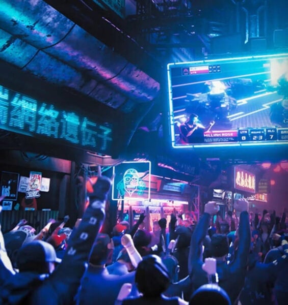 ROG Swift OLED PG32UCDMZ Canlı e-spor maçını izleyen kalabalık ve neon ışıklar altında heyecan dolu ortam, gaming ve esports tutkunları için ideal mekan.