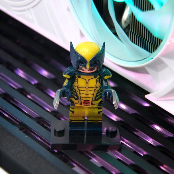 Yüksek detaylı LEGO Wolverine figürü, parlak neon ışıklar ve modern bilgisayar bileşenleriyle çevrili, oyun ve koleksiyon meraklıları için ideal, dikkat çekici masaüstü dekoru.